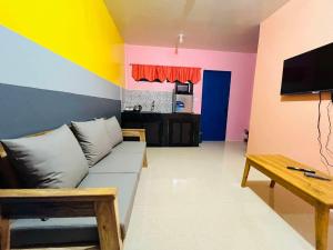a living room with a couch and a tv at AGs Place in Tagbilaran City