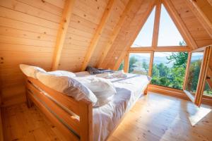 a bed in a room with a large window at Etno House Markovic in Kolašin