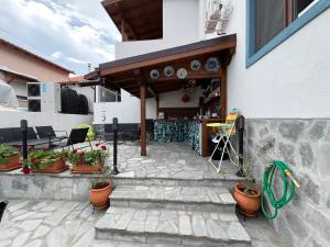 a patio with potted plants next to a building at Guest House Kalina,Studio 3 in Ammouliani