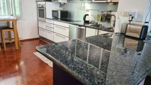a kitchen with a granite counter top in a room at 3-bedroom lake view and near center apartment with sauna in Lahti