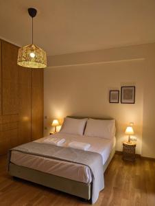 a bedroom with a large bed and a chandelier at Luxury Villa in Nature - Akrata Village in Akrata +37 photos