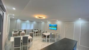a dining room with tables and chairs and a tv at Edelweiss in Lazeshchyna