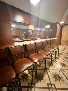 サマルカンドにあるAssalom Hostelのレストランに並んだ茶色のバースツール