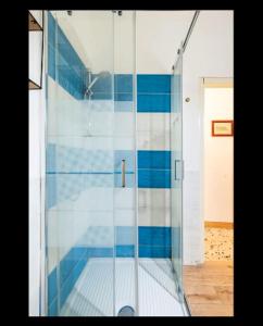 a glass shower with blue tiles in a room at Binario 8 Catania Stazione Centrale in Catania