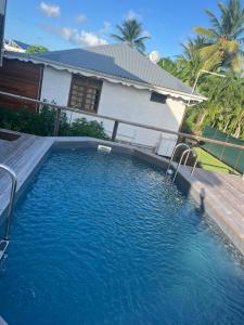 a swimming pool in front of a house at Les Alpinias in Sainte-Anne