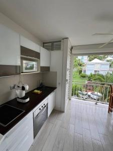 a kitchen with white cabinets and a large window at LA VIDA LOCA in Saint-François