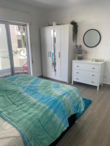 a bedroom with a bed and a dresser and a mirror at DyLary in Armação de Pêra