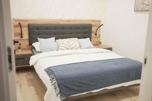 a bedroom with a large bed with a blue blanket at Apartman Marijana in Bjelovar