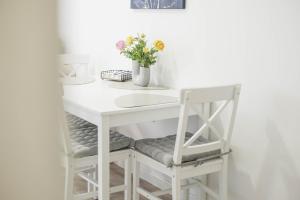 a white desk with a chair and a vase of flowers at Apartman Marijana in Bjelovar