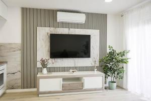 a living room with a television on a wall at Apartman Marijana in Bjelovar