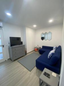 a living room with a blue couch and a tv at DyLary in Armação de Pêra
