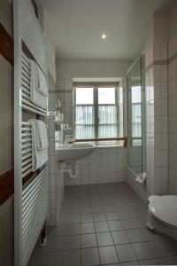 ein weißes Bad mit einem Waschbecken und einem WC in der Unterkunft Burghotel Stargard in Burg Stargard