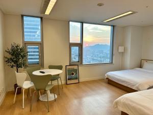 ソウルにある"GRAND OPENED" Maxtyle Guesthouse Dongdaemunのベッドルーム1室(ベッド1台、テーブル、椅子付)