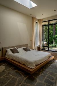 a large bed in a room with a large window at MAYA- Villas On The Lake in Curchi