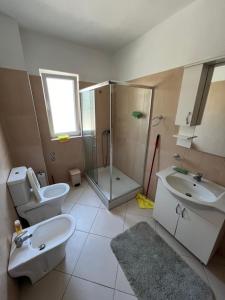 a bathroom with a sink and a toilet and a shower at The White Villa in Hamallë +23 photos