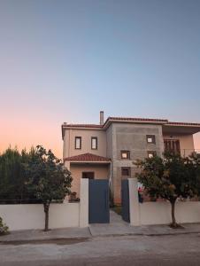 a house with two trees in front of it at Luxury Villa in Nature - Akrata Village in Akrata