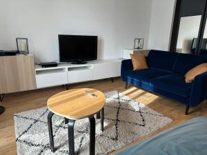 a living room with a blue couch and a table at Le Nid Provençal - Parking Inclus in Manosque