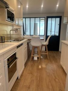 a kitchen with white cabinets and a table and chairs at Le Nid Provençal - Parking Inclus in Manosque +10 photos