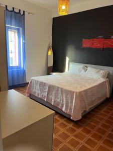 Un dormitorio con una cama grande y una ventana en Appartamento Navarra, en Santa Maria Navarrese