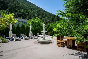 a fountain in the middle of a courtyard with chairs at BELAIR Rooms Montenegro in Sutorina
