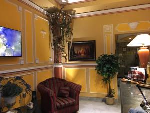 - un salon avec une chaise et une télévision dans l'établissement Hotel Amadeus, à Caserte