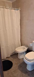 ein Badezimmer mit Toilette und Duschvorhang in der Unterkunft La Escondida in Valeria del Mar