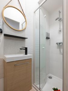 a bathroom with a shower and a sink and a mirror at La Petite Vienna - Vienna authentica in Vienne