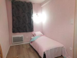 a small bedroom with a bed and a window at Maison des 2 Grottes in Estadens