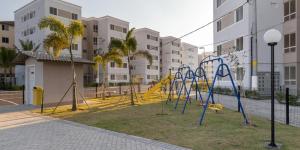 un parc avec une aire de jeux avec balançoires et toboggans dans l'établissement Apto Oeste simples Santa cruz, à Rio de Janeiro