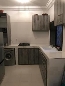 a kitchen with a sink and a washing machine at Maison de vacance Saly in Mbour