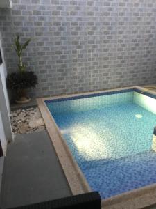 a large swimming pool with a brick wall at Maison de vacance Saly in Mbour +15 photos