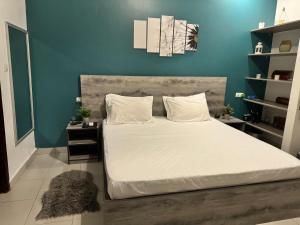 a bedroom with a large bed with a blue wall at Maison de vacance Saly in Mbour