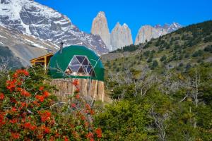 un edificio verde al lado de una montaña en Ecocamp Patagonia, en Torres del Paine