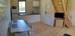 a kitchen and dining room with a table and a television at Domki pod lasem Sobieszewo in Gdańsk