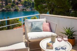 a balcony with a table with wine glasses on it at Holiday Home Dora in Splitska