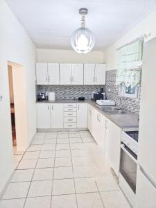 a kitchen with white cabinets and a tiled floor at Beach front house at Agios Ilias Pyrgos Near Ancient Olympia in Áyios Ilías
