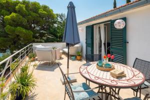 a patio with a table and an umbrella at Holiday Home Dora in Splitska