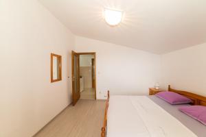 a bedroom with a large white bed with purple pillows at Villa Nada in Duće