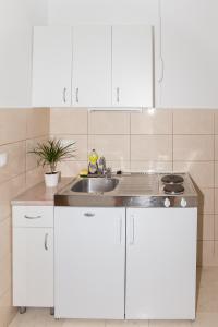 a kitchen with white cabinets and a sink at Villa Nada in Duće