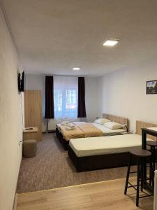 a hotel room with two beds and a table at 4 vodenice Brzeće B&B in Brzeće