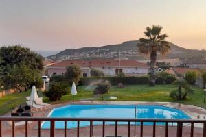 una piscina en un patio con una palmera en Stefania Exclusive Penthouse with Pool and Private Garden, en Castelsardo