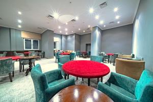 Una sala de espera con mesas y sillas y una mesa roja. en Grand Yazici Ski Hotel & Spa, en Uludag 280 fotos más