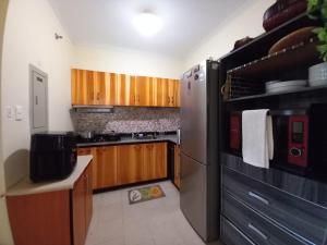 une cuisine avec des armoires en bois et un réfrigérateur en acier inoxydable dans l'établissement King Bed 2BR European Style City Center in Davao City Philippines, à Davao