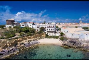 a group of buildings on a hill next to a beach at B&B Nuovo Capo Altano in Portoscuso