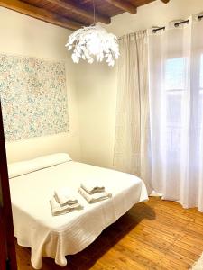 Un dormitorio con una cama con sábanas blancas y una lámpara de araña. en Bella Villa, en Villalpando 9 fotos más