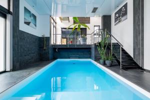 a large swimming pool with blue water in a house at Zen et Chic in Hindisheim