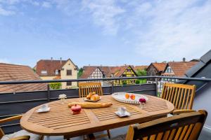 a wooden table on a balcony with a view of the city at Zen et Chic in Hindisheim