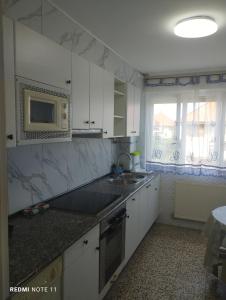 Una cocina con gabinetes blancos y un microondas. en Apartamento Vicsus, en Ajo 7 fotos más