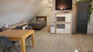 ein kleines Wohnzimmer mit einem Tisch und einem Bett in der Unterkunft DG VerWohn in Wiefelstede