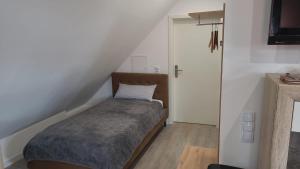 ein kleines Schlafzimmer mit einem Bett und einer Treppe in der Unterkunft DG VerWohn in Wiefelstede